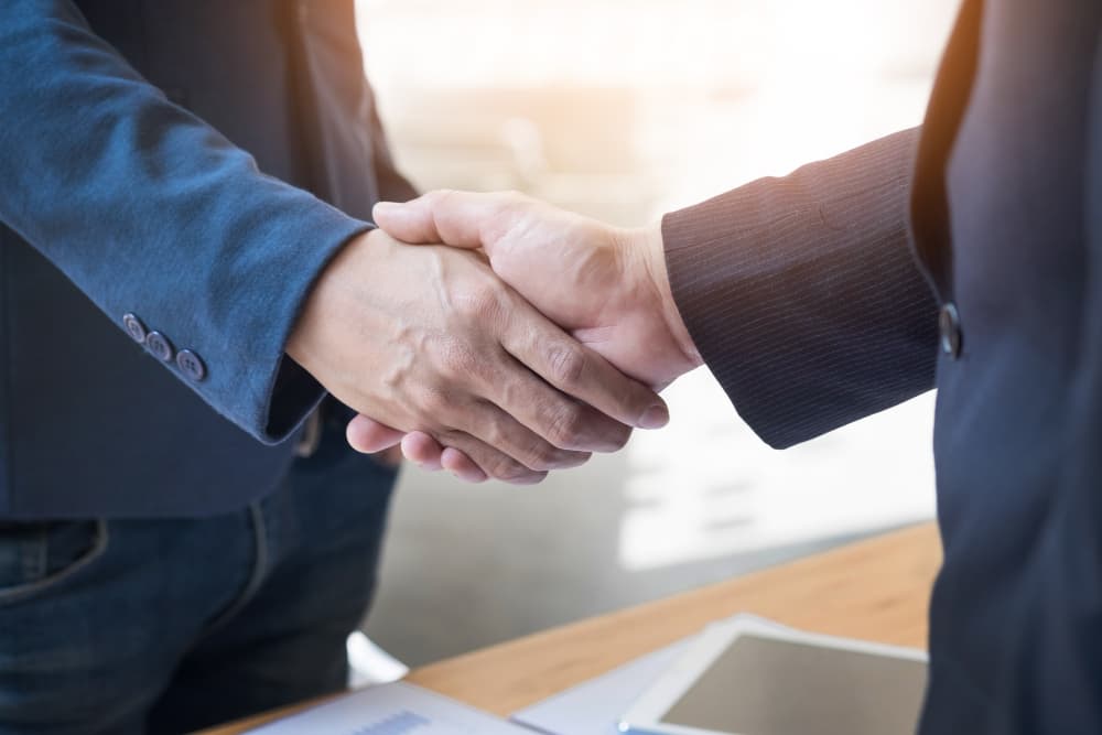 A professional handshake between an Ascora partner and a client.