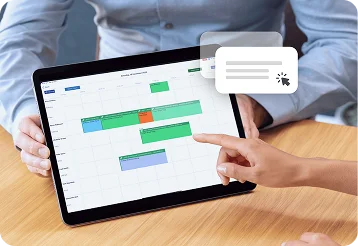 Person scheduling roofing jobs on a desktop calendar.